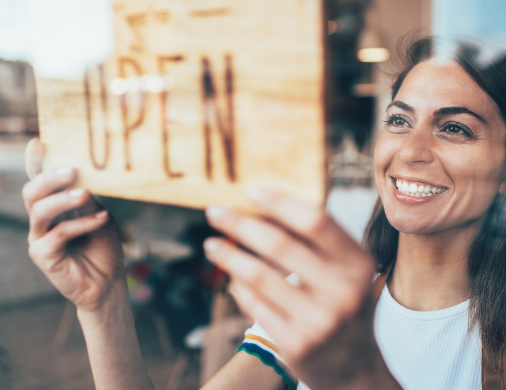 lady putting Open sign in window